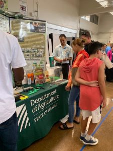 Plant Quarantine inspector Bishnu Bhandari talks with a family about invasive species